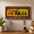 Wall mounted wooden key holder hanging in entryway with hand-painted folk art design